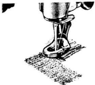 Gros plan sur l'aiguille d'une machine à coudre piquant un tissu (aucun texte ou symbole visible).
