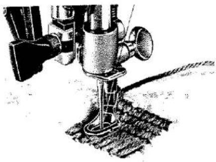 Illustration technique d'une aiguille de machine à coudre avec base et fermoir (aucun texte ni symbole)