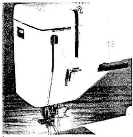 Illustration de l'aiguille d'une machine à coudre piquant le tissu (sans texte ni symboles visibles).