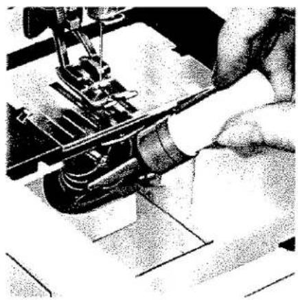 Gros plan de mains utilisant une machine à coudre (sans texte ni symboles visibles)