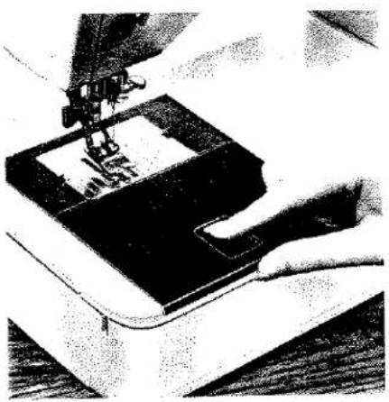 Gros plan sur l'aiguille d'une machine à coudre piquant le tissu, aucun texte ni symbole visible