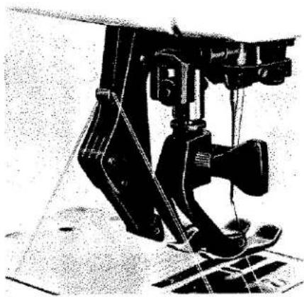 Photo en noir et blanc d'un dispositif mécanique avec un pied et un mécanisme à levier (sans texte ni symboles visibles).