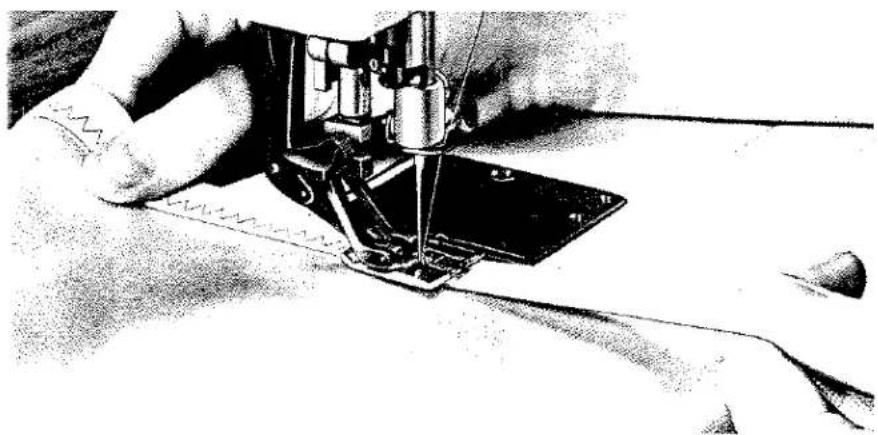 Gros plan d'une aiguille de machine à coudre piquant du tissu, sans texte ni symbole visible