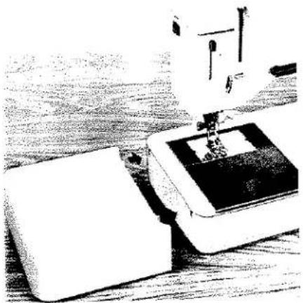 Photo en noir et blanc d'une aiguille de machine à coudre piquant un tissu, aucun texte ou symbole visible