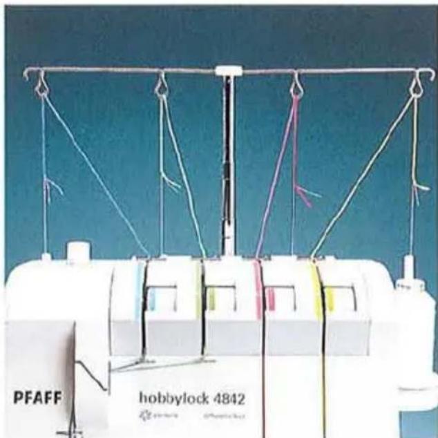 Gros plan d'une machine à coudre avec des fils enroulés et une marque visible « hobbylock 4842 » (aucun texte au-delà de l'étiquette).