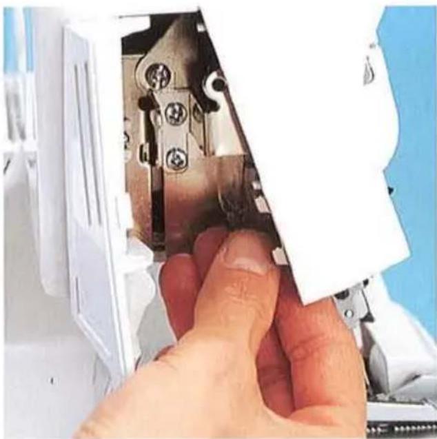 Gros plan d'une main insérant ou ajustant un composant mécanique dans un boîtier en plastique blanc (aucun texte ou symbole visible)