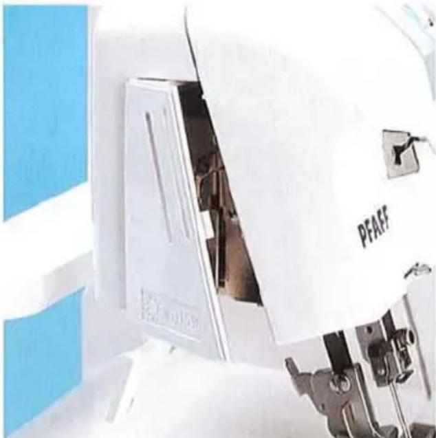 Gros plan d'une machine industrielle blanche étiquetée « PFAF » avec des panneaux bleus sur la gauche (aucun texte lisible au-delà de l'étiquette)