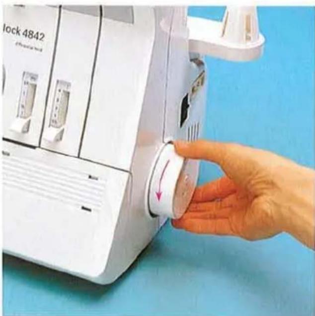 Main actionnant une machine industrielle blanche étiquetée « Lock 4842 » avec un indicateur à cadran circulaire, sur fond bleu (aucun texte ou symbole sur l'appareil lui-même).