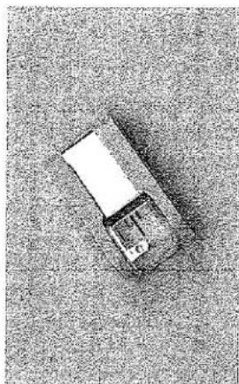 Vue de dessus d'un petit objet blanc reposant sur une surface texturée (aucun texte ou symbole visible)