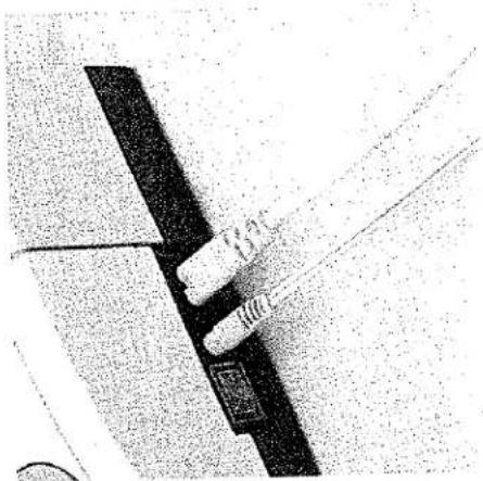 Gros plan d'un composant mécanique avec une tige filetée insérée dans un bloc rectangulaire (aucun texte ni symbole visible).