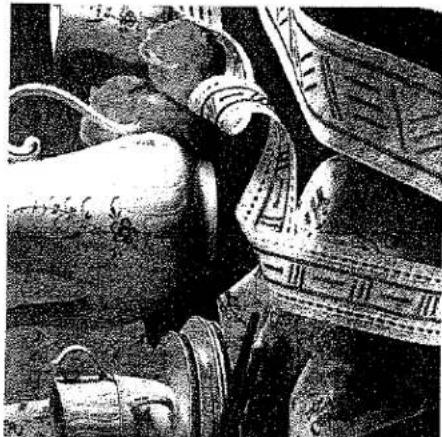 Photo en noir et blanc d'une personne portant une tenue traditionnelle avec des vêtements ornés (sans texte ni symboles visibles).