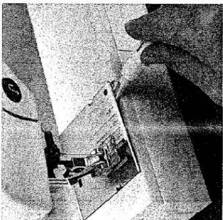 Gros plan de l'aiguille d'une machine à coudre piquant un tissu (sans texte ni symboles visibles).