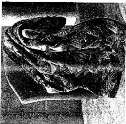 Photo en noir et blanc d'une figure sculptée en tenue traditionnelle, assise et debout (sans texte ni symboles visibles).