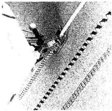 Photo en noir et blanc montrant un tracteur sur chenilles avec une grande route marquée de flèches noires et du texte chinois en dessous.