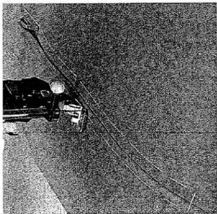 Gros plan sur l'aiguille d'une machine à coudre en train de coudre du tissu sur une surface sombre (aucun texte ou symbole visible)