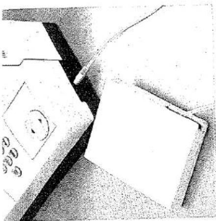 Photo en noir et blanc d'une imprimante avec un visage souriant et deux feuilles de papier vierges sur une surface (aucun texte ni symbole visible).