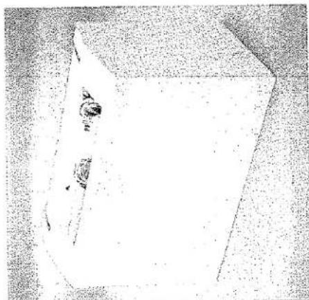 Dessin au trait simple d'un objet rectangulaire avec un petit élément circulaire sur le dessus (aucun texte ni symbole).