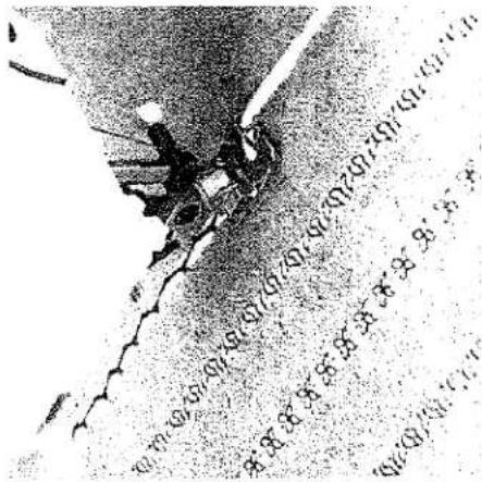 Photo en noir et blanc d'un véhicule endommagé avec des traces de pneus visibles et des panneaux d'avertissement