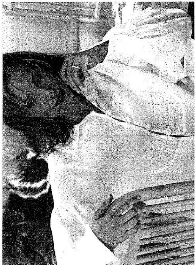 Photo en noir et blanc de deux personnes en conversation, l'une tenant une chemise blanche, sans texte ni symboles visibles.