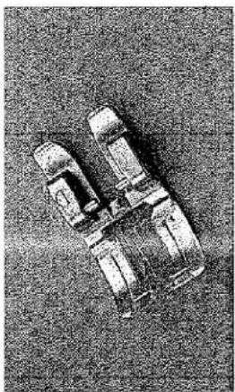 Vue de dessus d'une voiture miniature à trois roues avec un siège rectangulaire, posée sur une surface texturée (aucun texte ni symbole visible)