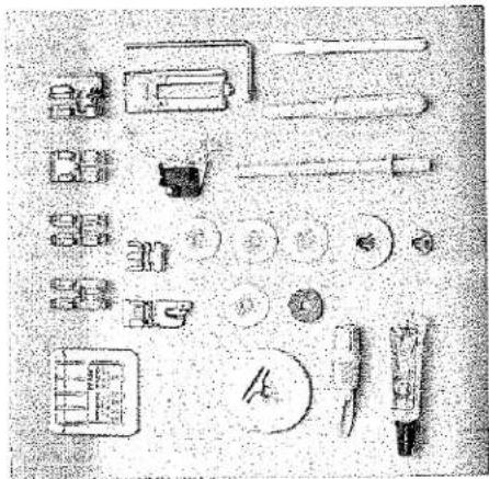 Collection de divers composants mécaniques et outils disposés sur une surface plane (aucun texte ou symbole visible)