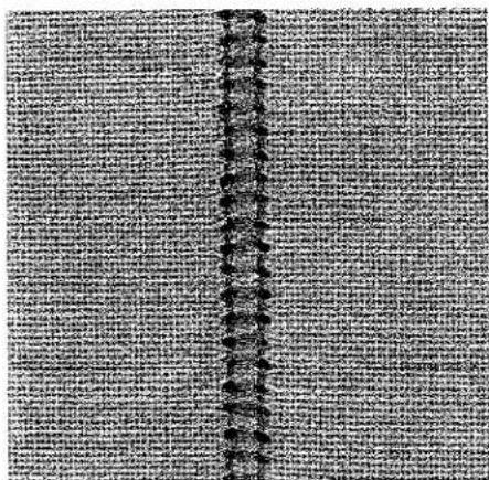 Gros plan d'un tissu texturé avec un motif de couture central (sans texte ni symboles).
