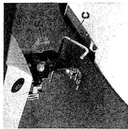 Gros plan de l'aiguille et du pied-de-biche d'une machine à coudre, montrant les composants mécaniques et la base (aucun texte ou symbole visible).