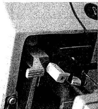 Gros plan sur un composant mécanique avec un mécanisme à marteau et levier (aucun texte ou symbole visible)