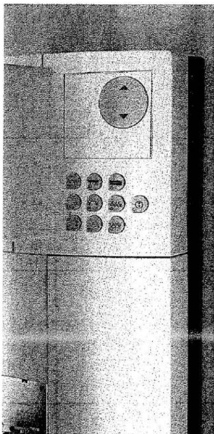 Gros plan d'un panneau de commande avec des boutons circulaires et un bouton rotatif (aucun texte ou symbole visible)