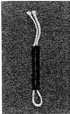Gros plan d'une corde noire attachée avec une sangle blanche, isolée sur un fond texturé sombre (sans texte ni symboles).