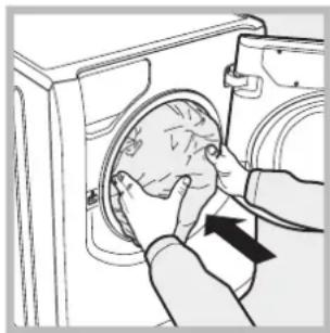 Line drawing of a hand inserting a circular component into a washing machine (no text or symbols)