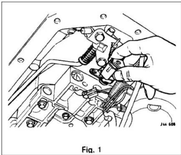 Technical line drawing of a hand adjusting mechanical components in a vehicle engine (no text or symbols)