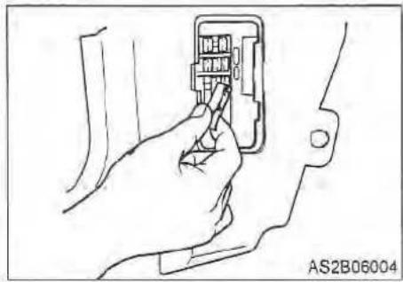 Line drawing of a hand inserting an internal component into a terminal block (no text or symbols)