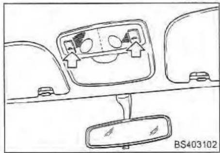 Interior view of a car dashboard with front and rear seats, showing dashboard display and directional arrows (no text or symbols)