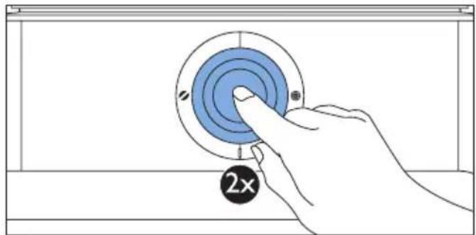 Hand pressing a button on a blue circular component labeled '2x' (no text or symbols beyond the label)