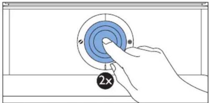 Hand pressing a button on a blue circular component labeled '2x' (no text or symbols beyond the label)