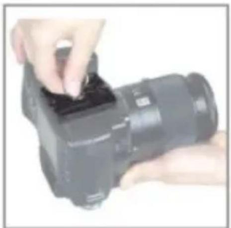 Close-up of hands holding a black DSLR camera module (no visible text or symbols)