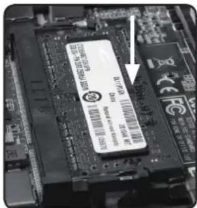 Close-up of a computer motherboard with visible chip labels and an arrow pointing to a specific component.