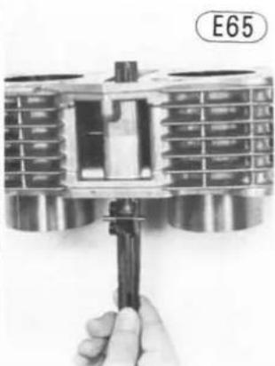 Close-up of a hand holding a mechanical piston component, no visible text or symbols on the device itself