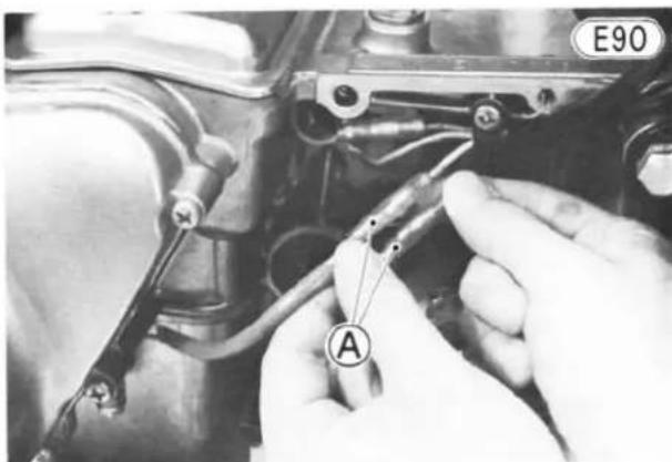 Close-up of hands using a tool to adjust or install components on an engine (no visible text or symbols)