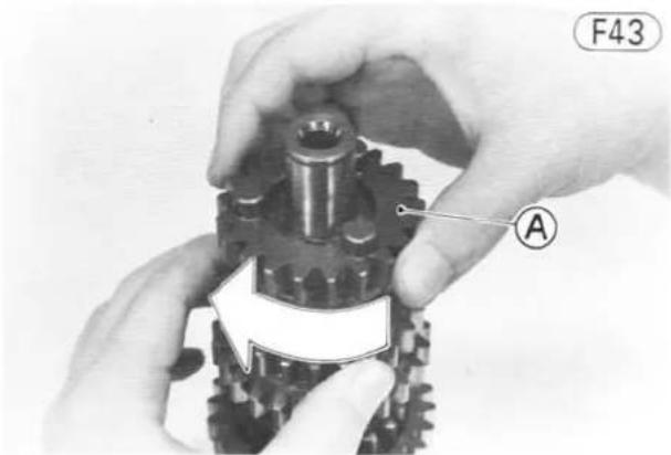 Close-up of hands assembling a mechanical gear assembly (no text or symbols visible)