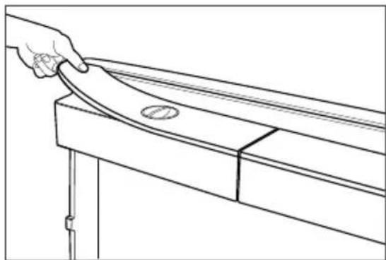 Line drawing of a hand holding a curved object on a wooden table (no text or symbols).