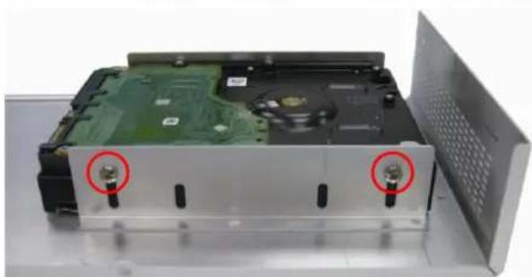Internal view of a computer drive chassis showing internal components and a green circuit board (no text or symbols visible)