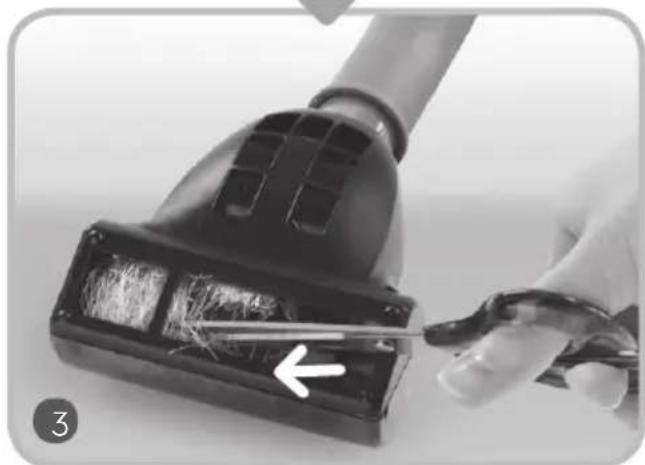 Close-up of a hand using scissors to cut a black vacuum cleaner with visible brush (no text or symbols)