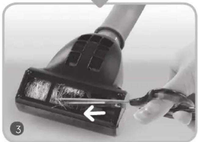 Close-up of a hand using scissors to cut a black vacuum cleaner with visible brush (no text or symbols)