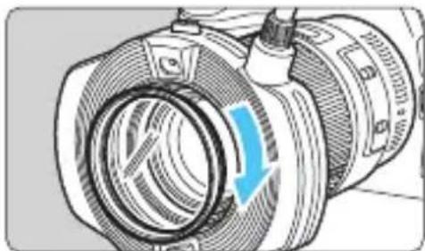 Illustration of a camera lens with a blue arrow indicating rotation (no text or symbols present)