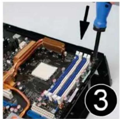 Close-up of a computer motherboard with a screwdriver inserted, showing internal circuitry and a numbered callout (3) — no text or symbols on the main subject.