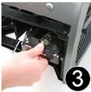 Close-up of a hand inserting a small electronic component into a computer oven (no visible text or symbols)