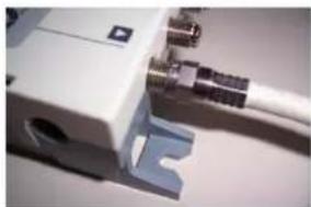 Close-up of a white electronic device with attached black connectors and a blue bracket (no visible text or symbols)