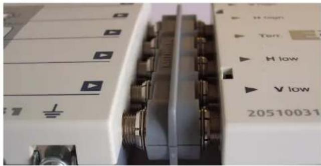 Close-up of industrial electronic equipment with labeled buttons and ports (no readable text or symbols beyond labels)